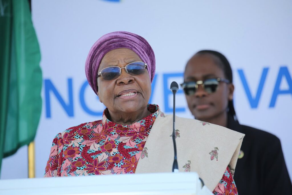 WhatsApp Image 2026-08-23 at 43320 PM - The Brief | Namibia's Leading Business & Financial News Elderly African woman in a purple head wrap and colorful floral dress speaks at a podium with a microphone.