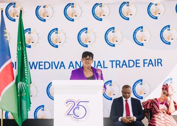 WhatsApp Image 2026-08-24 at 82924 AM - The Brief | Namibia's Leading Business & Financial News Woman in a purple blazer speaks at a podium during a trade fair stage with flags nearby and a branded backdrop reading 'Wediva Annual Trade Fair'.