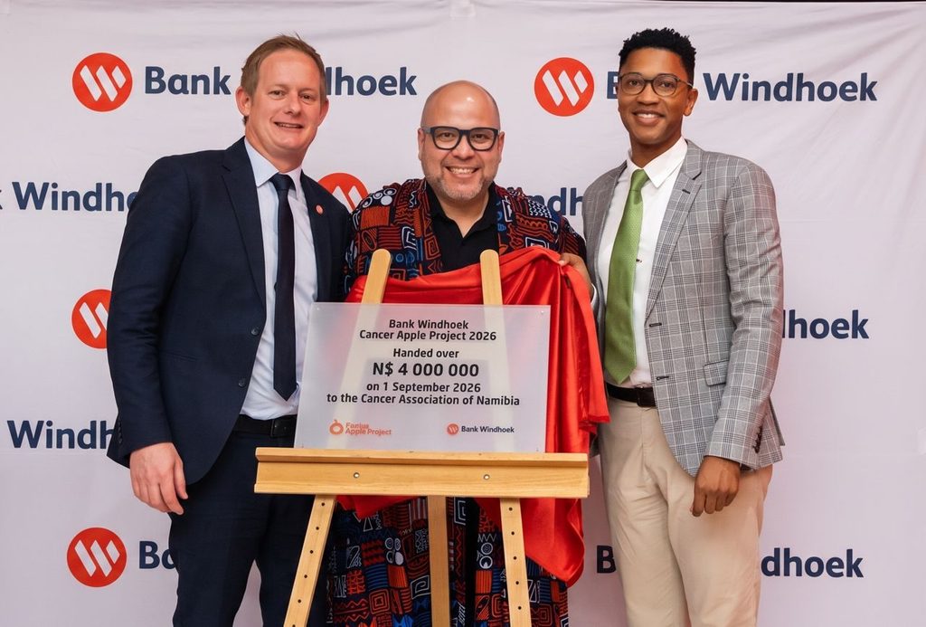 WhatsApp Image 2026-09-01 at 35410 PM - The Brief | Namibia's Leading Business & Financial News Three men pose with a draped plaque on a wooden easel at a Bank Windhoek event, the red cloth pulled aside to reveal the donation plaque.