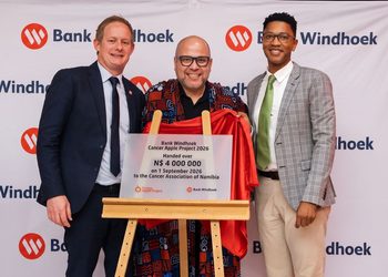 WhatsApp Image 2026-09-01 at 35410 PM - The Brief | Namibia's Leading Business & Financial News Three men pose with a draped plaque on a wooden easel at a Bank Windhoek event, the red cloth pulled aside to reveal the donation plaque.