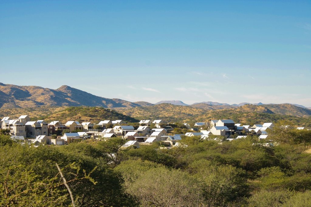 WhatsApp Image 2026-09-02 at 85121 AM - The Brief | Namibia's Leading Business & Financial News Cluster of white-roofed houses nestled in a desert landscape with hills under a blue sky.