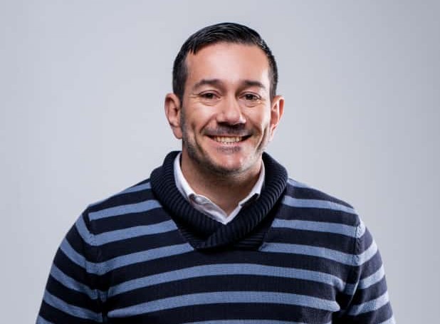 Paulo Coelho - The Brief | Namibia's Leading Business & Financial News Smiling man with short dark hair wearing a navy and gray striped sweater, light background.