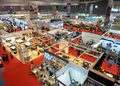 WhatsApp Image 2026-09-07 at 51018 PM - The Brief | Namibia's Leading Business & Financial News Aerial view of a busy exhibition hall filled with white booth structures, red-carpet aisles, and attendees exploring stalls.