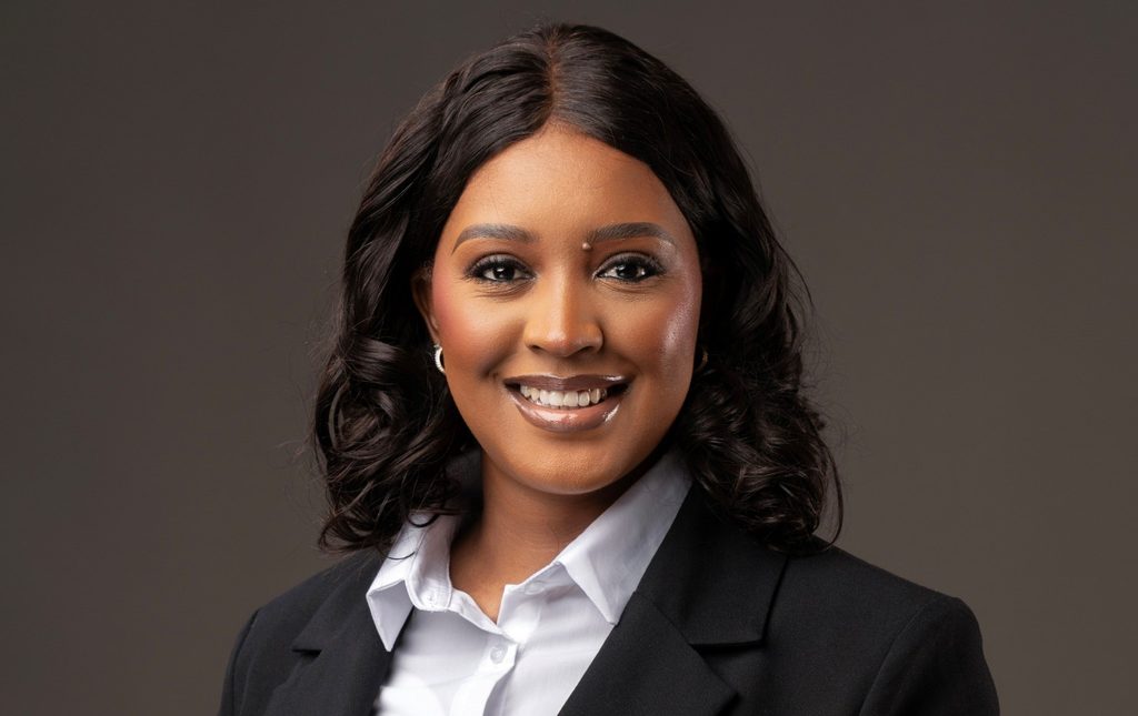 Veripura Muukua1 - The Brief | Namibia's Leading Business & Financial News Professional headshot of a smiling woman in a black blazer and white shirt against a neutral backdrop.