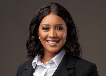 Veripura Muukua1 - The Brief | Namibia's Leading Business & Financial News Professional headshot of a smiling woman in a black blazer and white shirt against a neutral backdrop.