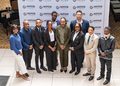 Ten professionals stand together for a group photo at a NIPDB event, backdrop shows repeated NIPDB logos and branding.