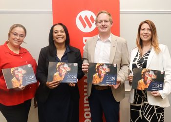 WhatsApp Image 2026-09-09 at 44834 PM - The Brief | Namibia's Leading Business & Financial News Four professionals pose together, each holding a 2026 Social Value Report booklet in front of a red banner with a white logo.