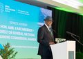 KAIRE MBUENDE6 - The Brief | Namibia's Leading Business & Financial News Speaker at a podium delivering the keynote at the African Green Industries Summit, with a blue screen behind him displaying event details