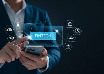 FINTECH - The Brief | Namibia's Leading Business & Financial News Person in a suit uses a smartphone with glowing fintech icons and a blue 'FINTECH' label