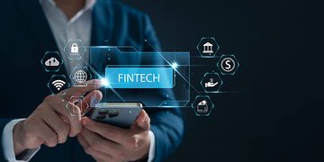 Person in a suit uses a smartphone with glowing fintech icons and a blue 'FINTECH' label