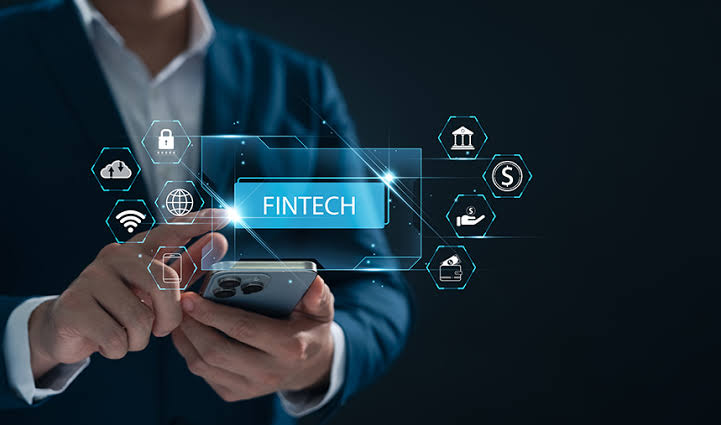 FINTECH - The Brief | Namibia's Leading Business & Financial News Person in a suit uses a smartphone with glowing fintech icons and a blue 'FINTECH' label