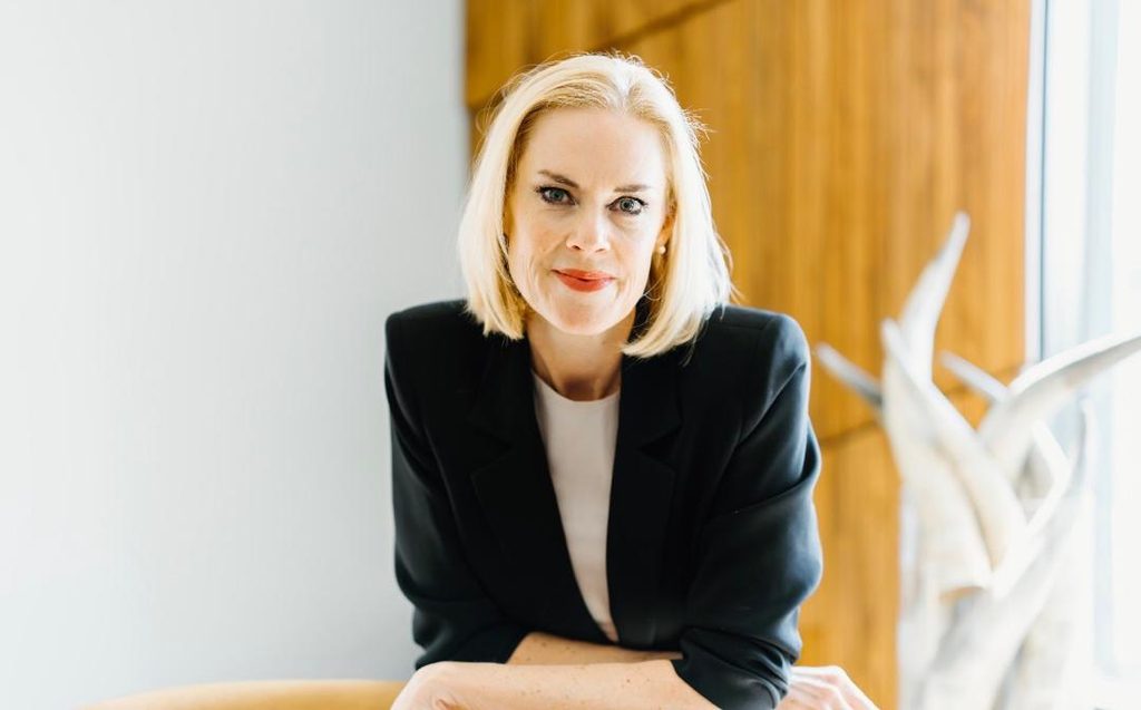 KIRTSY FNB - The Brief | Namibia's Leading Business & Financial News Professional woman with blonde hair in a black blazer, seated indoors beside a window. (informative)