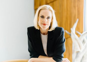 KIRTSY FNB - The Brief | Namibia's Leading Business & Financial News Professional woman with blonde hair in a black blazer, seated indoors beside a window. (informative)