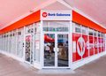 Exterior view of a Bank Gaborone branch with a glass storefront and bright red branding above the entrance, showing the logo and signage clearly.