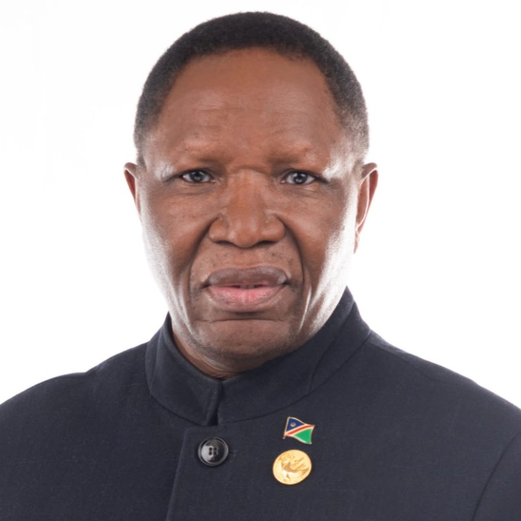 WhatsApp Image 2026-09-26 at 125947 - The Brief | Namibia's Leading Business & Financial News Portrait of a middle-aged man in a black high-collar jacket, wearing a small flag pin and a gold medal.