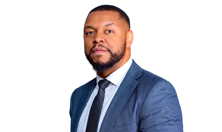 Professional headshot of a Black man in a navy suit and tie, looking at the camera against a black background.