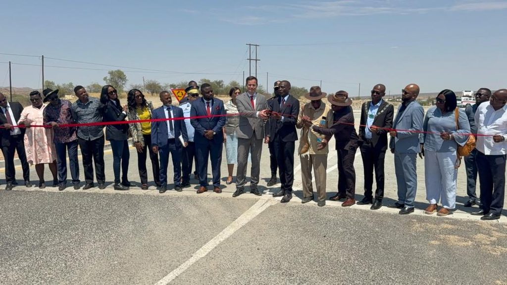 WhatsApp Image 2026-10-09 at 110949 AM - The Brief | Namibia's Leading Business & Financial News Group of officials and community members standing on a highway, cutting a red ribbon to open a new road.