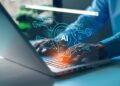 Hands typing on a laptop with a glowing blue AI holographic network overlay above the keyboard.