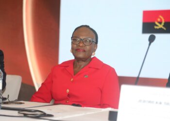 WhatsApp Image 2026-10-19 at 152641 - The Brief | Namibia's Leading Business & Financial News Professional woman in a red blazer and glasses sits at a panel table during a conference, with a microphone nearby and documents in front of her.