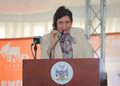WhatsApp Image 2026-10-20 at 100122 - The Brief | Namibia's Leading Business & Financial News Woman in a beige blazer with a scarf speaks at a wooden lectern, delivering a speech into a microphone with a crest on the front panel.