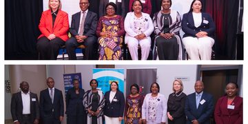 Group of diverse professionals in formal attire posing for a conference photo indoors with banners in the background