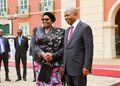 WhatsApp Image 2026-10-21 at 45240 PM - The Brief | Namibia's Leading Business & Financial News Two formally dressed leaders shake hands and smile on a red carpet outside a pastel building.