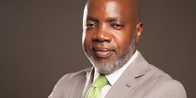 Professional headshot: bald man in a gray suit and lime green tie, smiling slightly.