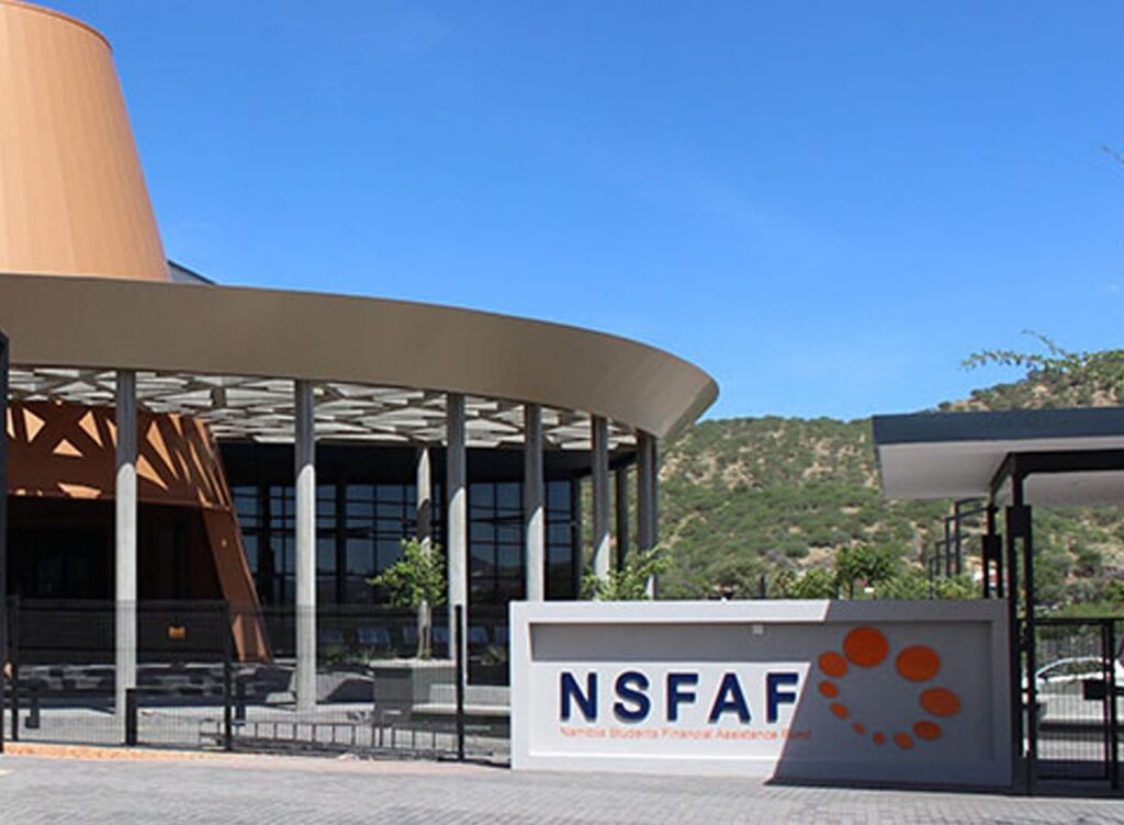 Modern campus building with a curved beige roof, glass walls, and a foreground sign reading NSFAF with an orange dot logo.
