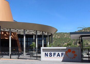 NSFAF1 - The Brief | Namibia's Leading Business & Financial News Modern campus building with a curved beige roof, glass walls, and a foreground sign reading NSFAF with an orange dot logo.