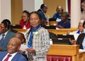 SHAFUDAH7 - The Brief | Namibia's Leading Business & Financial News Woman standing with papers at a formal meeting, speaking to colleagues seated around a conference desk.