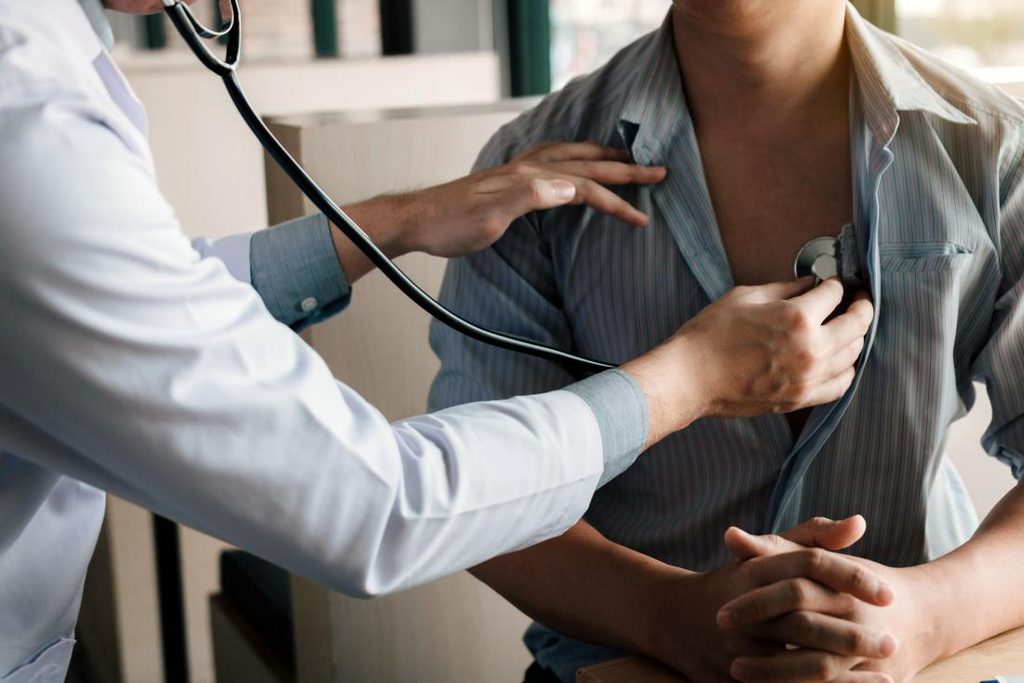 Doctor uses a stethoscope to listen to a patient's chest during a checkup.
